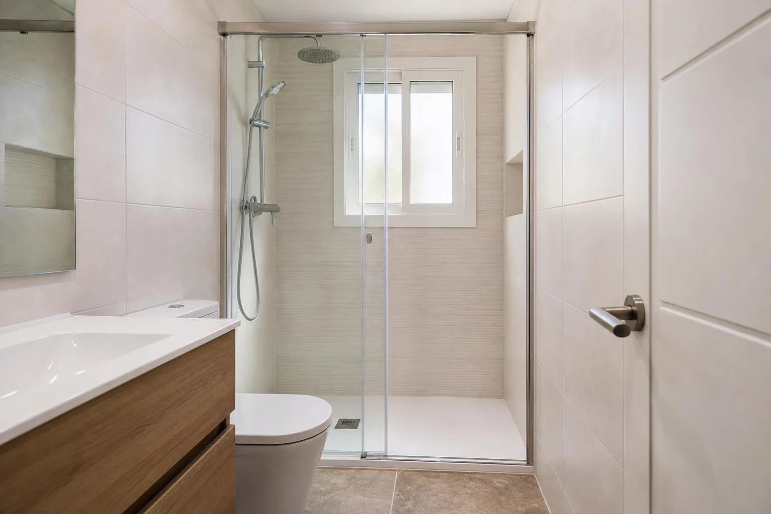 Baño estrecho con plato de ducha blanco y mampara corredera