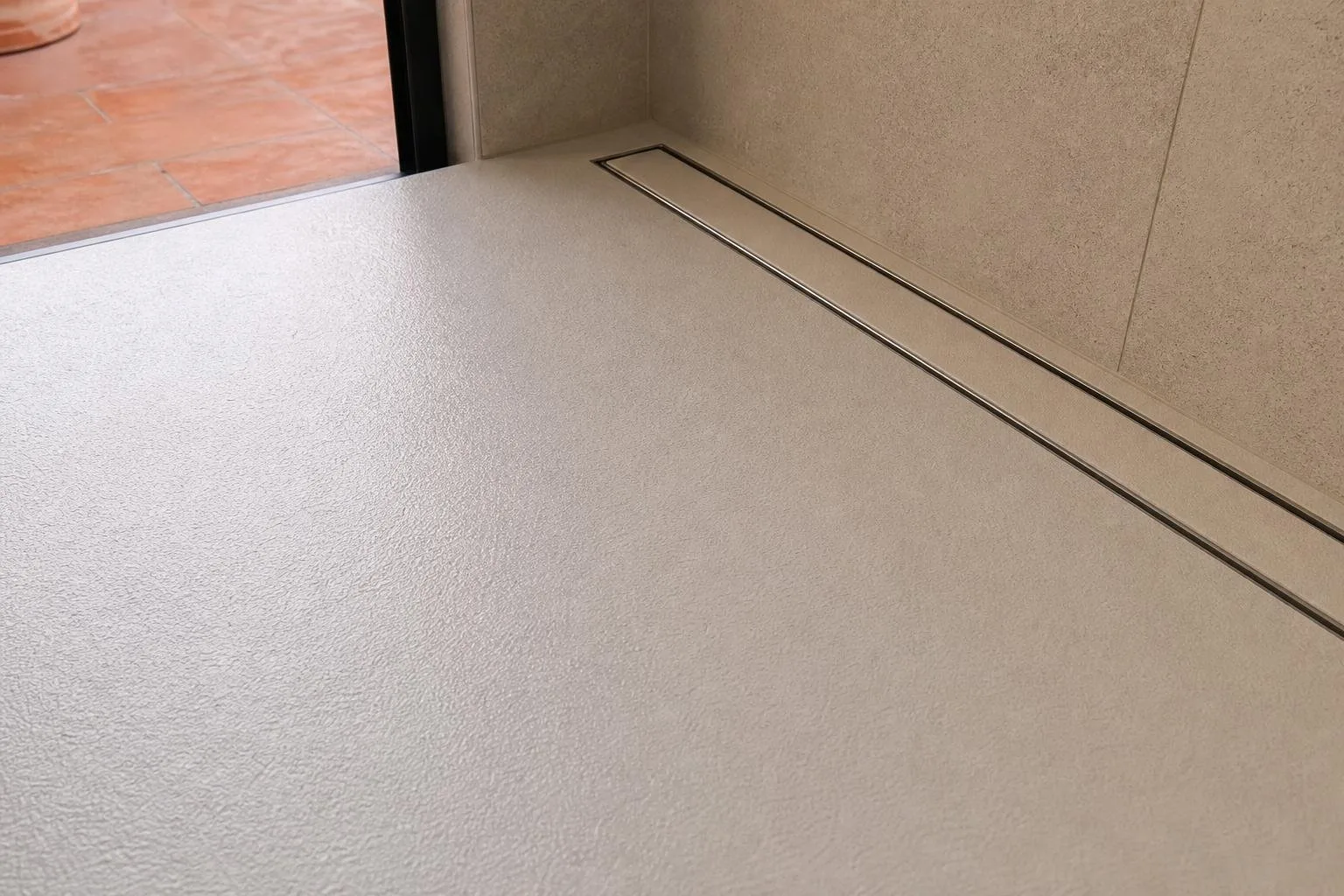 Detalle de plato de ducha antideslizante con desagüe lineal