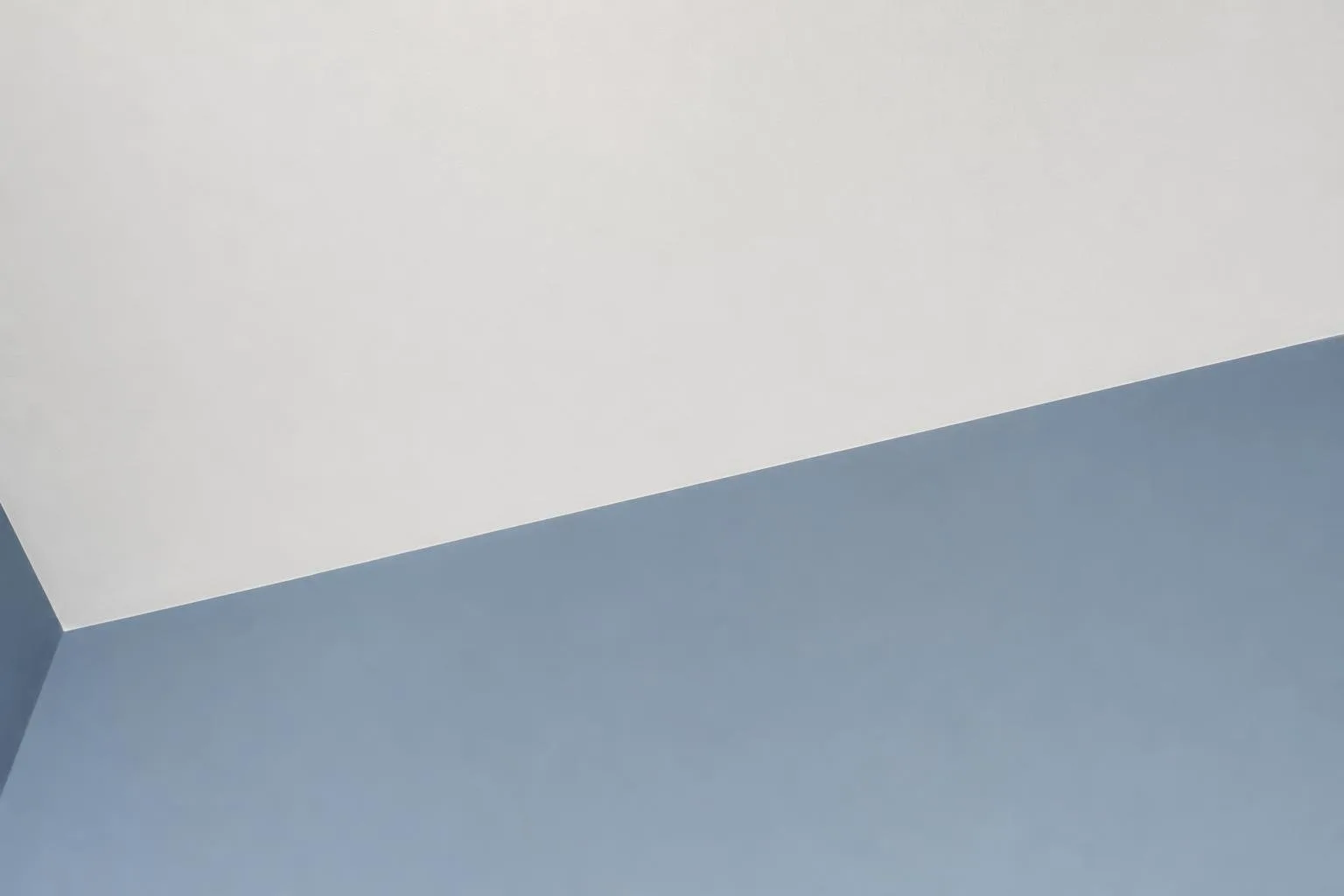 Detalle de la línea limpia entre pared pintada y techo blanco