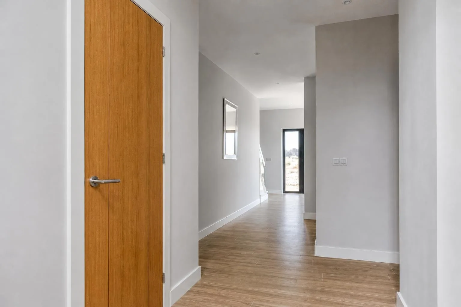 Pasillo pintado en gris suave con rodapié blanco